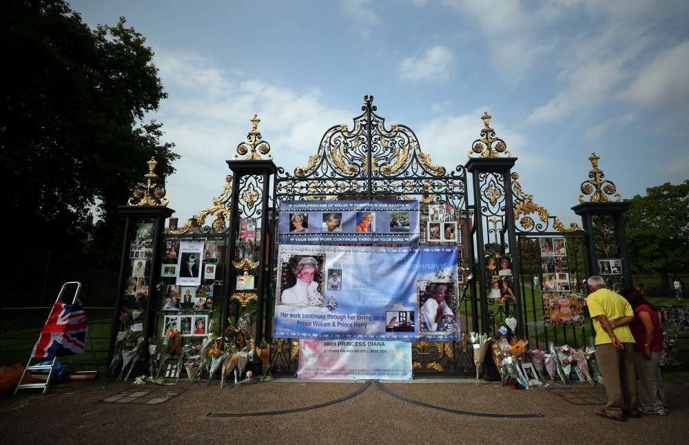People leave flowers and tributes in memory of the late Princess Diana at the gates of her former residence Kensington Palace in London.