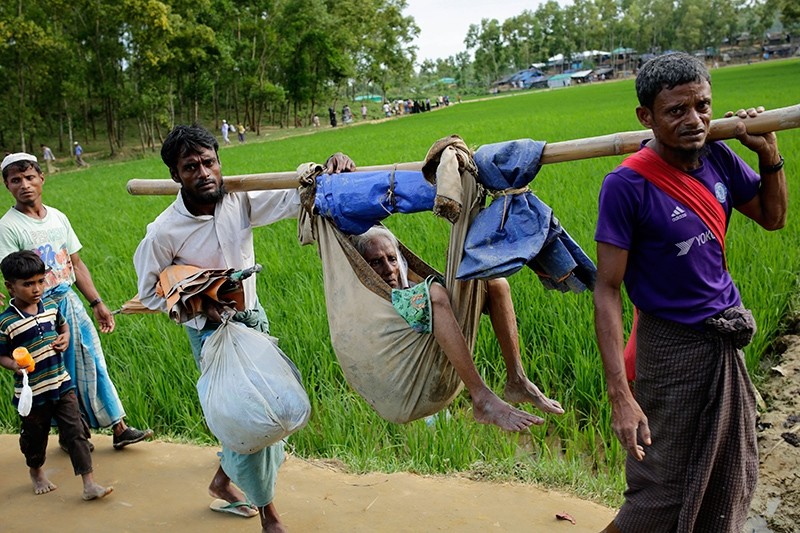 Two Rohingya men carry their mother in a hammock as they walk into a refugee camp in Ukhiya, Cox's Bazar, Bangladesh, Sept. 11, 2017. (EPA Photo)