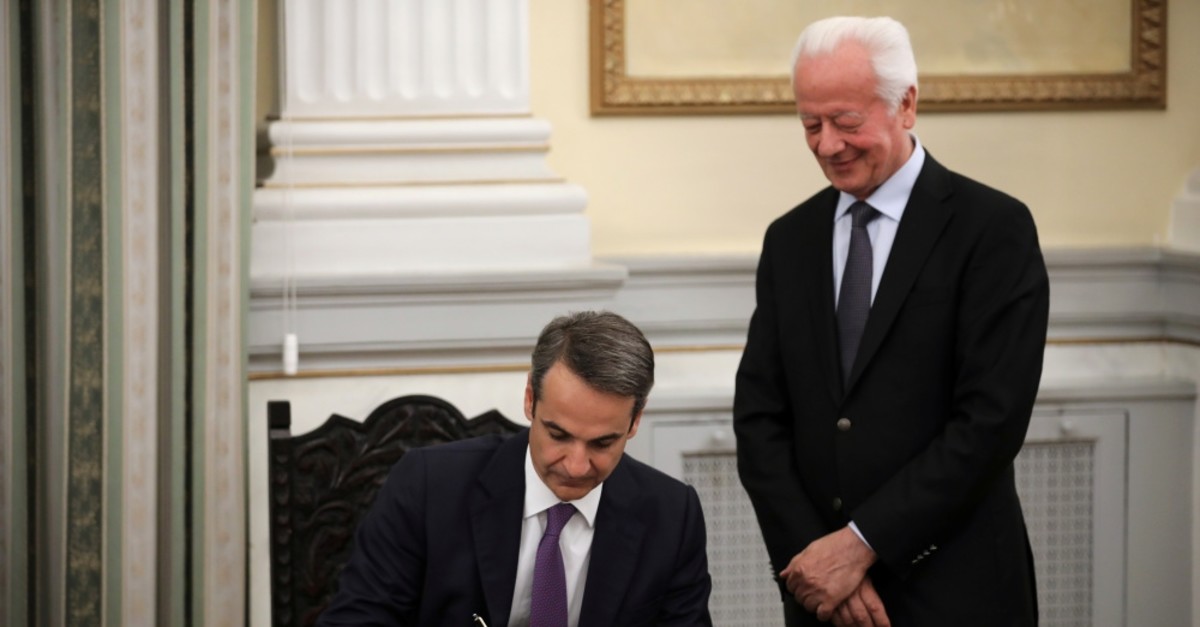 Greece's new Prime Minister Kyriakos Mitsotakis signs a document during a swearing-in ceremony at the Presidential Palace, Athens, July 8, 2019.