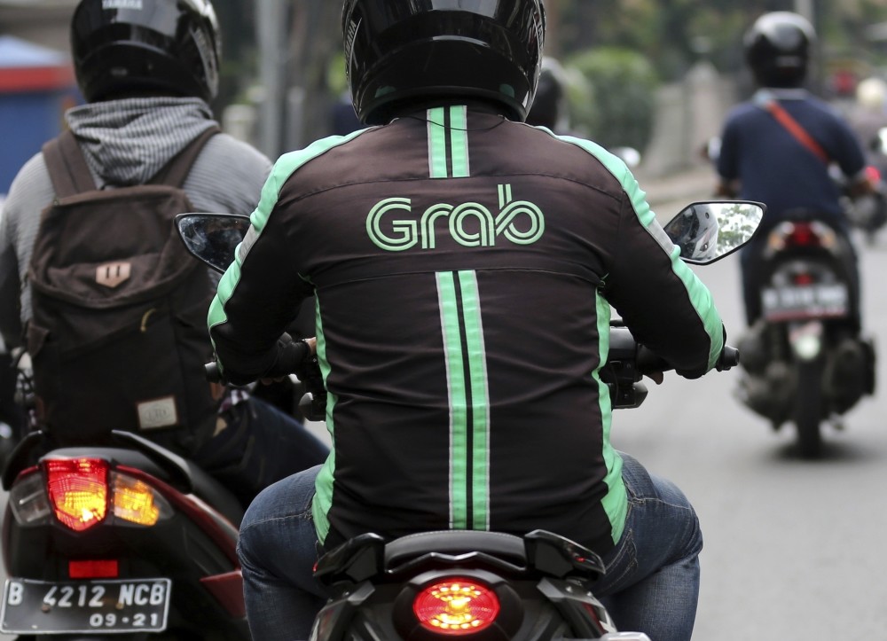 A GrabBike driver rides on a motorbike in Jakarta, Indonesia.