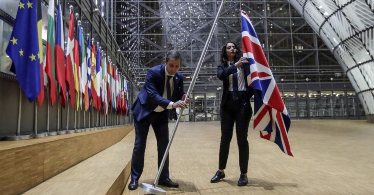 EU Council staff members remove the U.K. flag from the European Council building in Brussels on Brexit Day, Jan. 31, 2020. (AFP Photo)