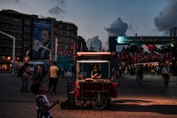 A man sells chestnuts in Taksim square under a campaign poster of President Erdou011fan, Istanbul, July 18.