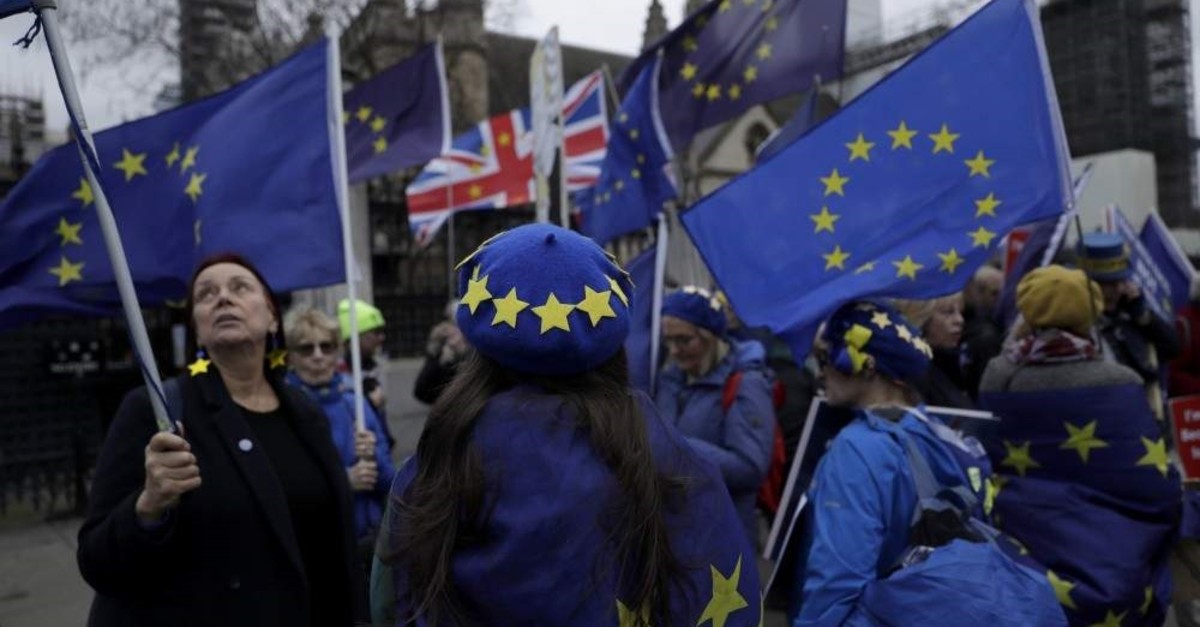 Anti-Brexit protesters hold European flags and wear European flag design berets as they demonstrate outside the Houses of Parliament in London, on the day of Prime Minister's Questions taking place inside, Jan. 8, 2020. (AP Photo)