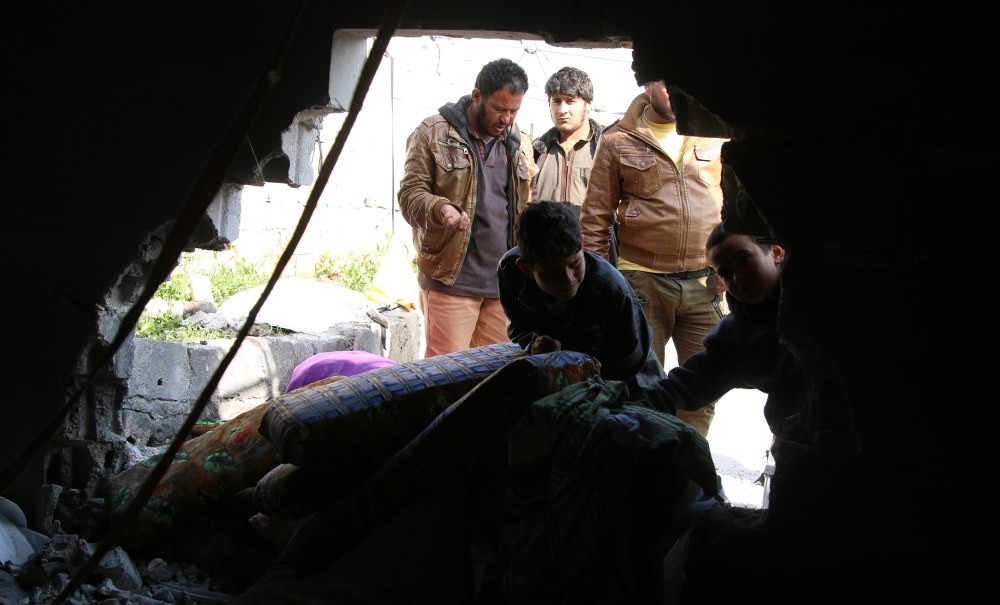 Refugees try to safe their belongings from a makeshift tent that was reportedly damaged by a mortar shell allegedly fired by the YPG in Atma, a town in the northern countryside of Idlib, Syria.