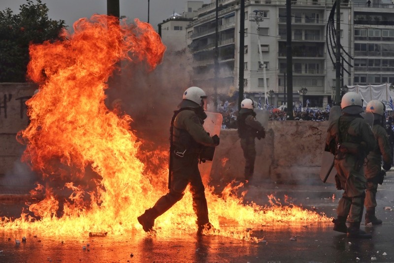 A molotov cocktail explodes next to Greek riot police during clashes after a rally in Athens, Sunday, Jan. 20, 2019. (AP Photo)