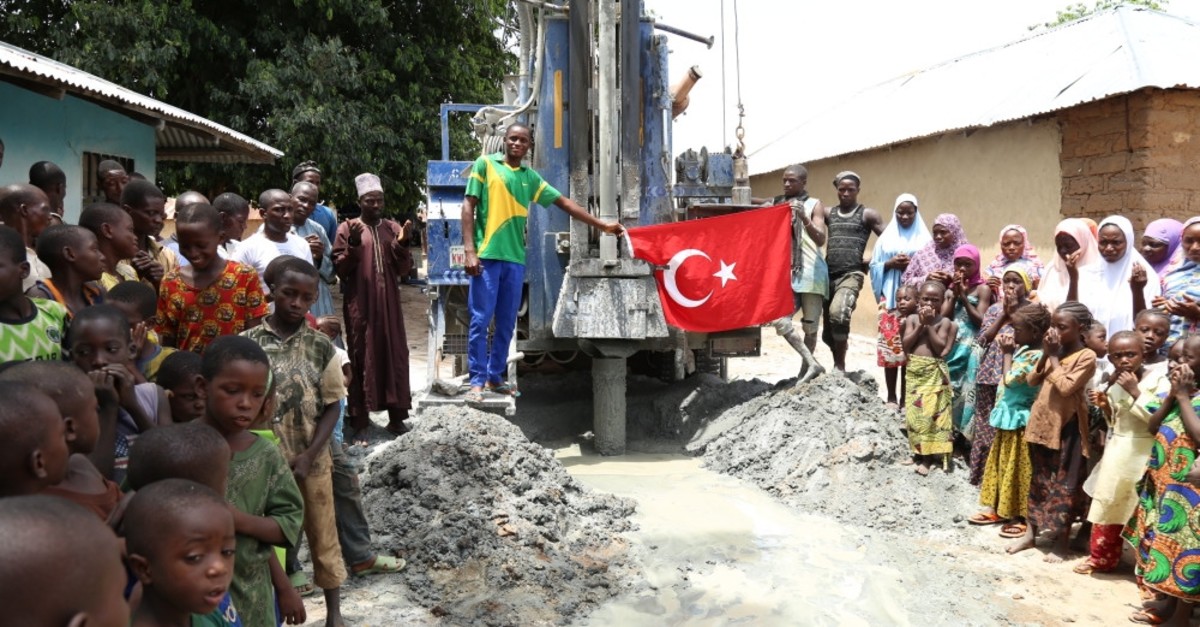People look on as a water well is drilled in Nigeria's Kwali by a Turkish charity, June 10, 2019.