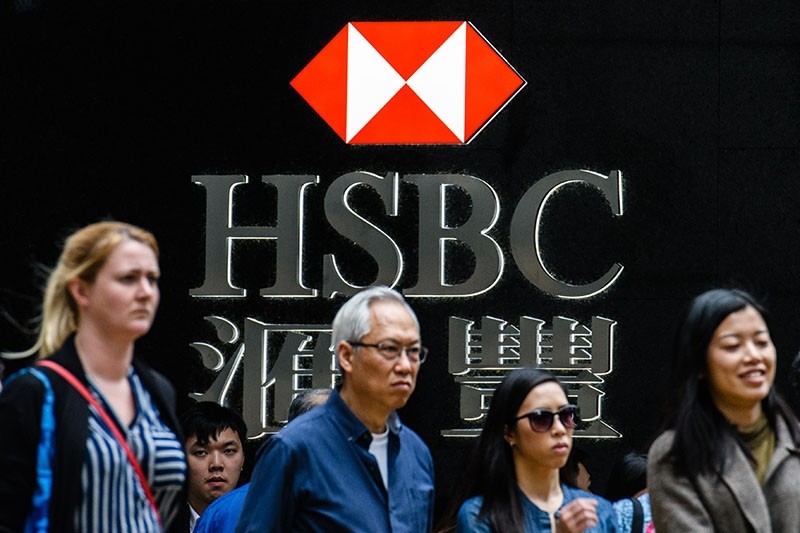 Pedestrians stand outside a branch of HSBC bank in Hong Kong on Feb. 20, 2018. (AFP Photo)