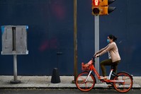 A woman rides a bike wearing a face mask in Mexico City, May 17, 2019.