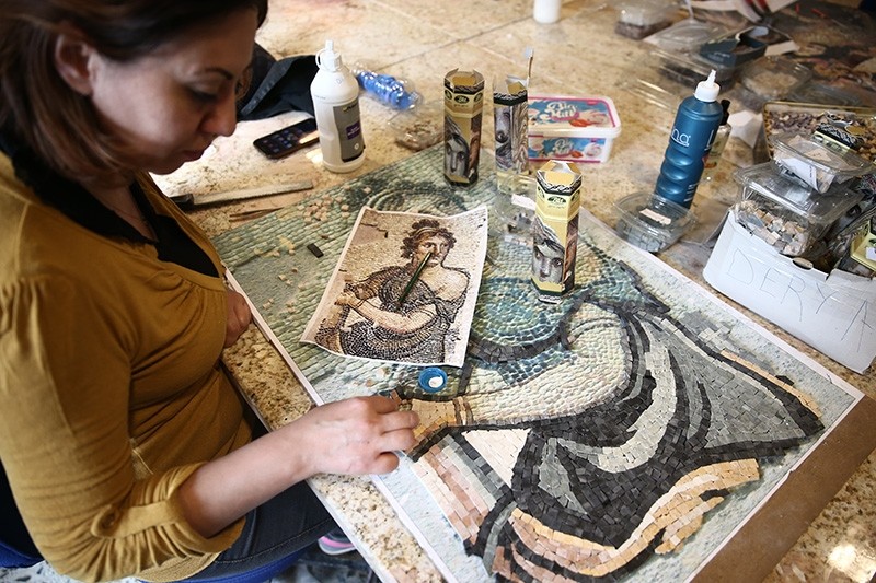 A student of Gaziantep, Turkey's mosaic course imitates the style of an ancient mosaic on display at the Zeugma Mosaic Museum (AA Photo)