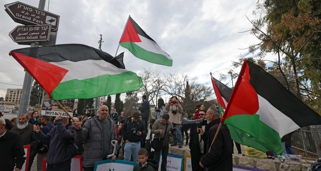 نشطاء إسرائيليون وفلسطينيون يرفعون الأعلام الفلسطينية في مظاهرة ضد إخلاء فلسطينيين من منازلهم في حي الشيخ جراح بالقدس الشرقية، 13 يناير 2023 الفرنسية