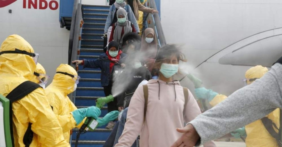 Medical officers spray Indonesian nationals with antiseptic after they arrive from Wuhan at Hang Nadim Airport Batam, Feb. 2, 2020. (Reuters Photo)