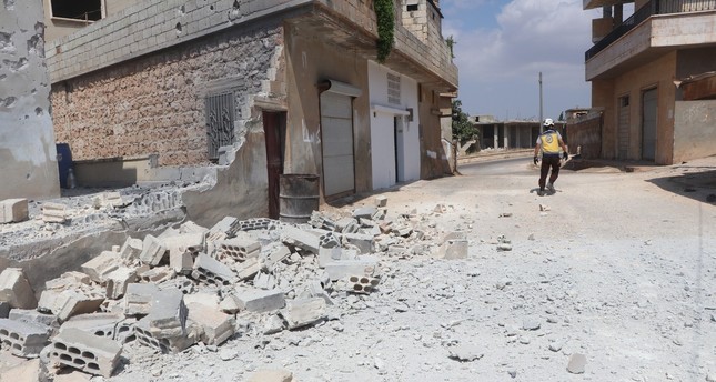 أحد عناصر الدفاع المدني السوري الخوذ البيضاء يتفقد مكان القصف في قرية البارة جنوبي محافظة إدلب شمال غربي سوريا، 9-7-2023 صورة: الدفاع المدني السوري