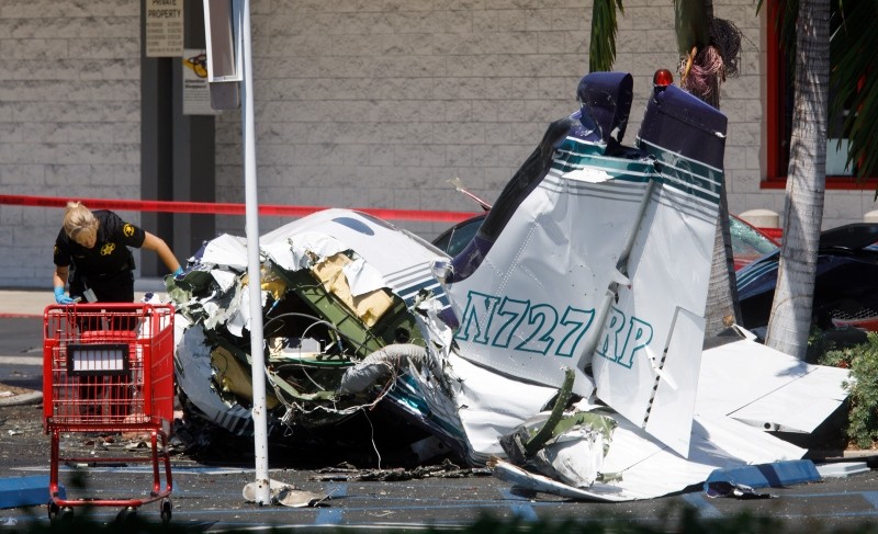 An investigator looks over the wreckage of a small plane that crashed into a strip mall parking lot in Santa Ana, California, USA, 05 August 2018. (EPA Photo)