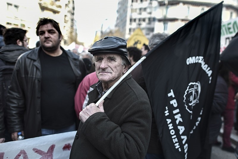 A Greek farmer holds a flag during a protest against new tax hikes and pension reforms that are part of Greece's austerity programme during an anti-austerity demonstration on February 14, 2017 in central Athens. (AFP Photo)