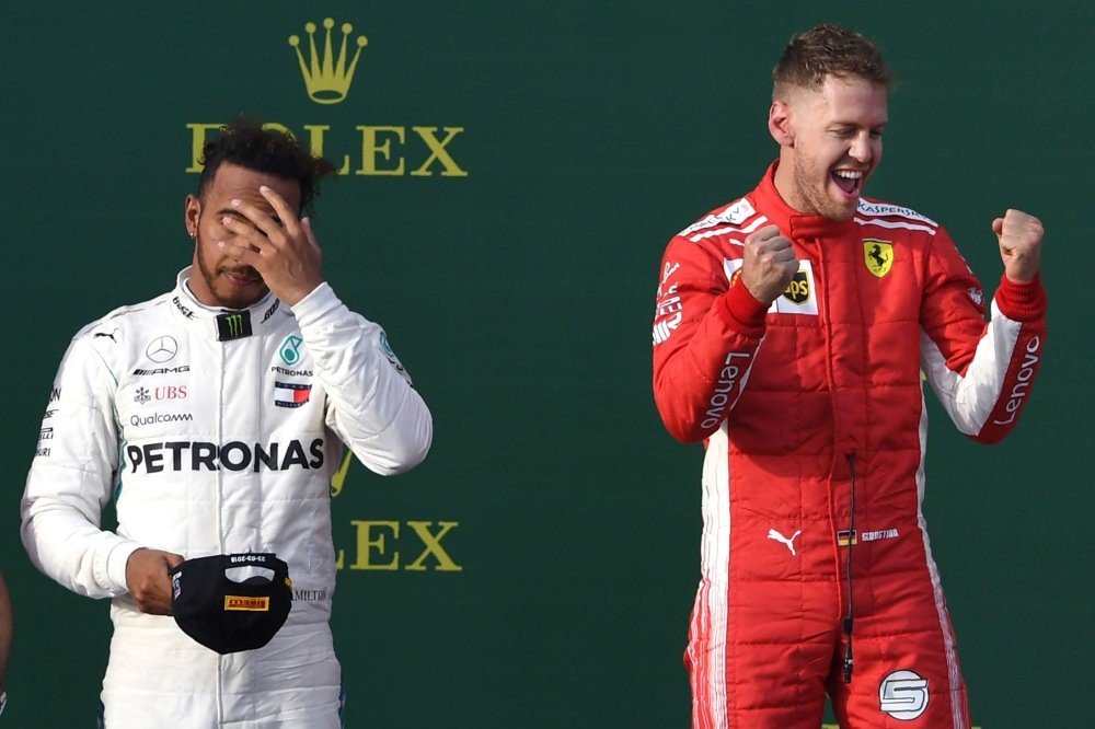 Ferrariu2019s Vettel celebrates his win on the podium with Mercedesu2019 Hamilton in the background on March 25.