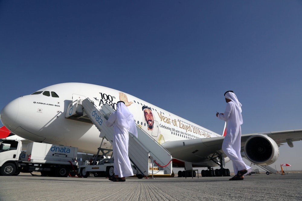 Visitors walk next to an Airbus A380, showing a picture of United Arab Emirates's former President Sheikh Zayed bin Sultan al-Nahayan during the Dubai Airshow in Dubai, United Arab Emirates, Nov. 13.