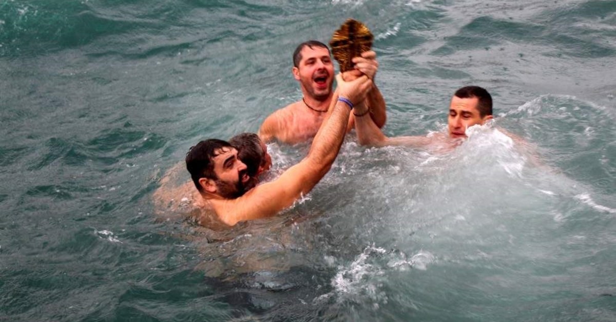 Swimmers hold the cross thrown into the sea off the shore of Sar?yer, Istanbul, Jan. 6, 2020. (DHA Photo)