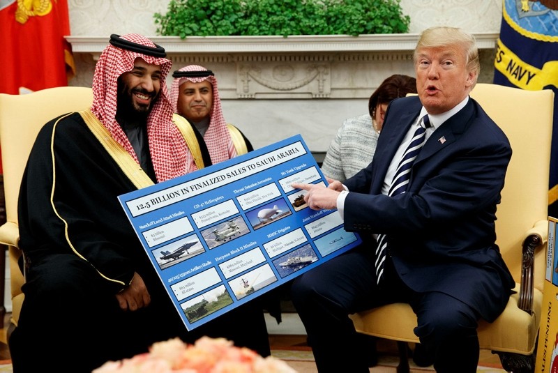 President Donald Trump shows a chart highlighting arms sales to Saudi Arabia during a meeting with Saudi Crown Prince Mohammed bin Salman in the Oval Office of the White House on March 20, 2018, in Washington. (AP Photo)