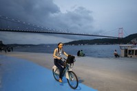 A woman rides near Istanbulu2019s water front with the bike she rented from u0130SBIKE.