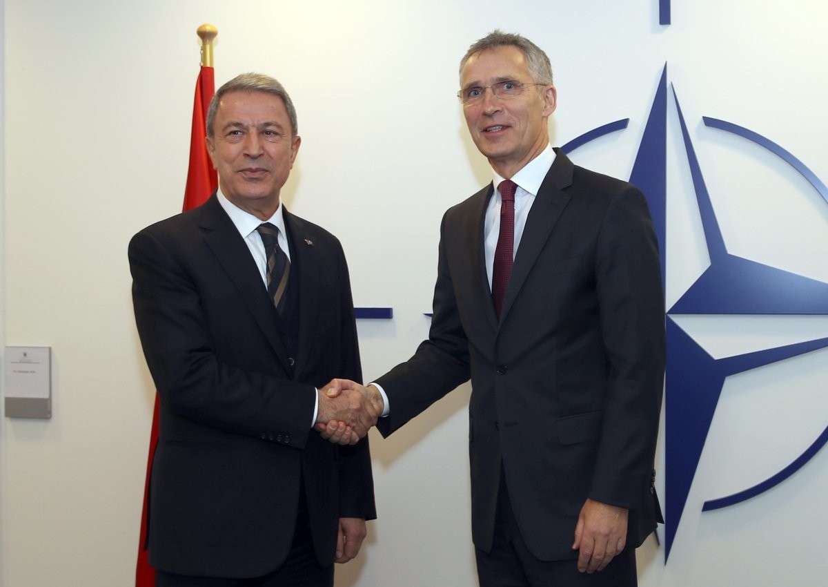 Defense Minister Hulusi Akar shakes hands with NATO Secretary-General Jens Stoltenberg during a NATO defense ministers meeting in Brussels, Feb. 13, 2019.