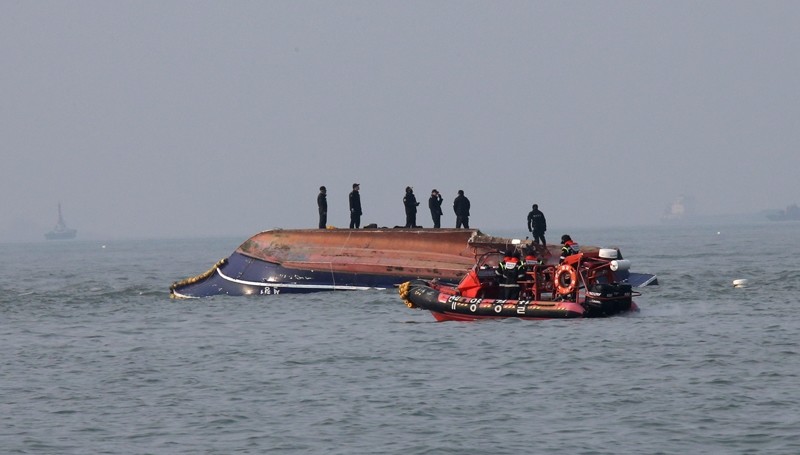 In this photo provided by South Korea's Ongjin County, South Korean Coast Guard officers try to rescue a capsized fishing boat which collided with a refueling vessel in the waters off Incheon, South Korea ( AP Photo)