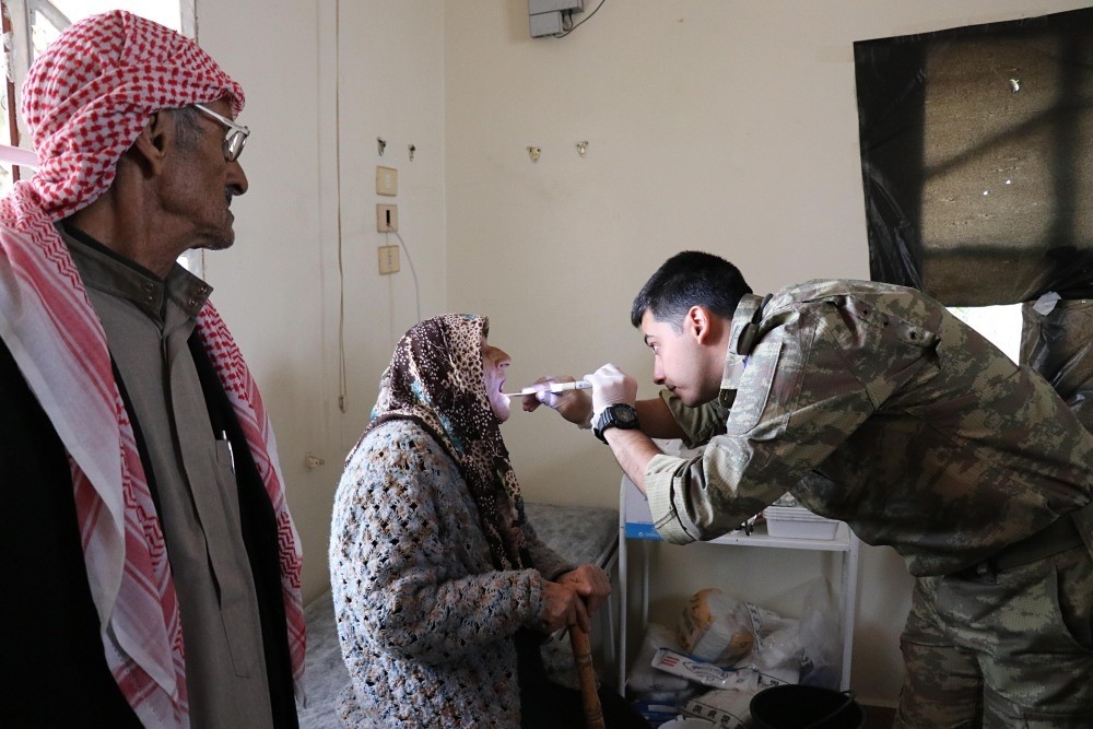 A Turkish officer treats an Afrin local at a medical clinic in rural Afrin.