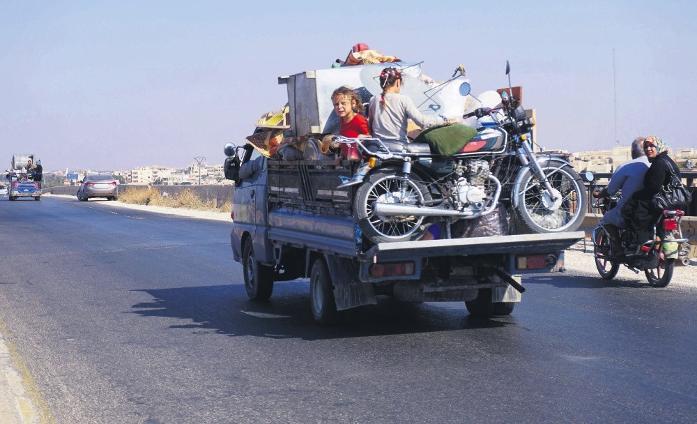 Syrian children on a truck loaded with furniture fleeing with their family from the conflict zone in Idlib;  many others like them are preparing to leave the town due to the uncertain future of their homeland, Sept. 11.