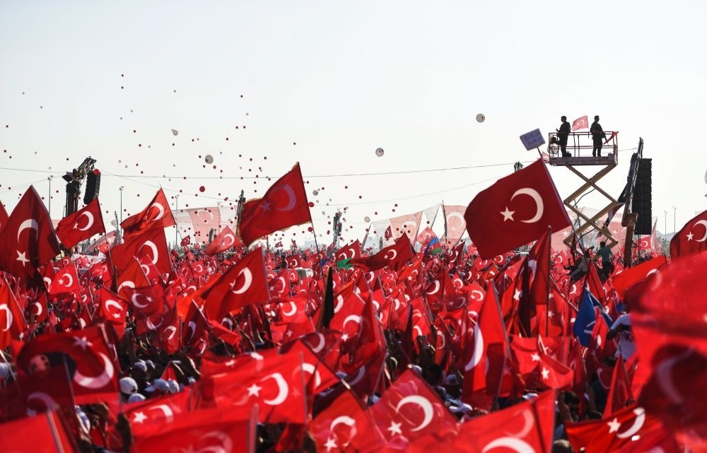 People wave Turkish flags as they stand in front of giant screens during a rally against the failed coup attempt by Gu00fclenist officers, Aug. 7, 2016. 