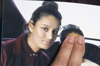 Renu Begum, eldest sister of missing 19-year-old UK girl Shamima Begum, holds a picture of her sister taken with another girl, whose face is covered in the photo to protect her identity, while being interviewed by the media in London, Feb. 22, 2015