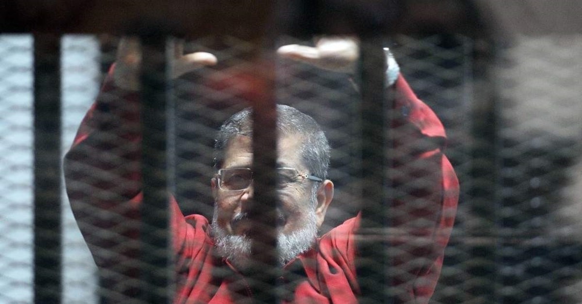 Egypt's first democratically elected President Mohammed Morsi stands behind bars, June 21, 2015. (AFP PHOTO)