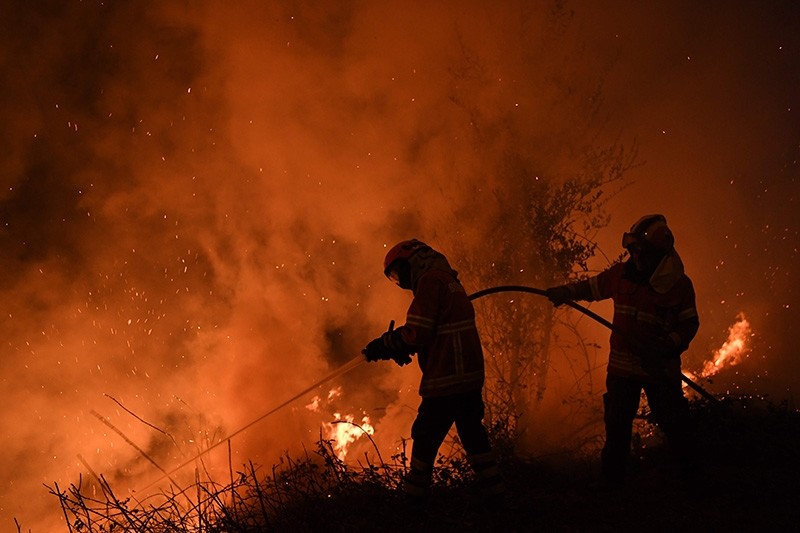 Firefighters try to extinguish a fire in Cabanoes near Louzan as wildfires continue to rage in Portugal on October 16, 2017. (AFP Photo)