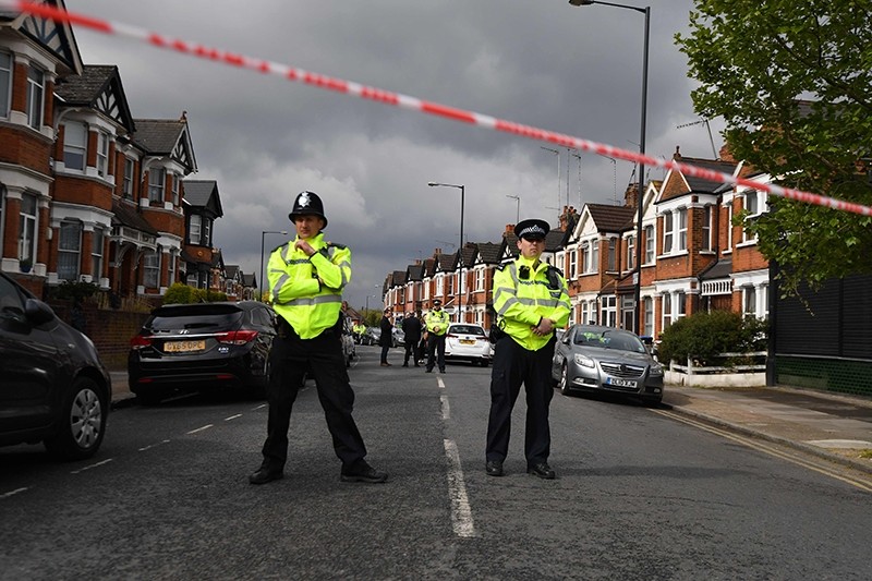 British police officers secure a cordon in a residential street in north-west London on April 28, 2017 where firearms officers shot a female subject after they carried out a specialist entry into an address. (AFP Photo)