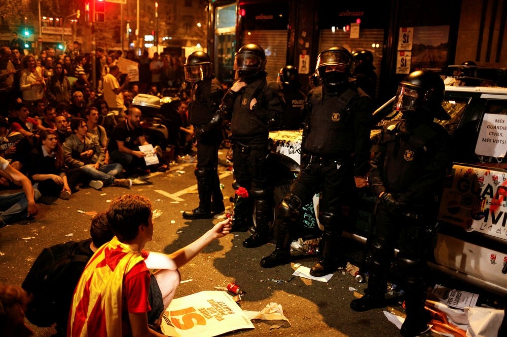 Officers of the Civil Guard stand next to their patrol car, which was damaged by protesters outside the Catalan region's Economy Ministry in Barcelona, Sept. 21.