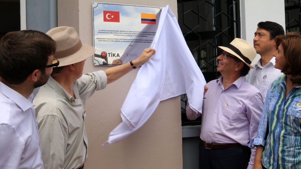Colombian President Santos, second from left, Turkish Ambassador Engin Yu00fcru00fcr, right, and Tu0130KA representative Mehmet u00d6zkan, left, unveil name plaque of the school.
