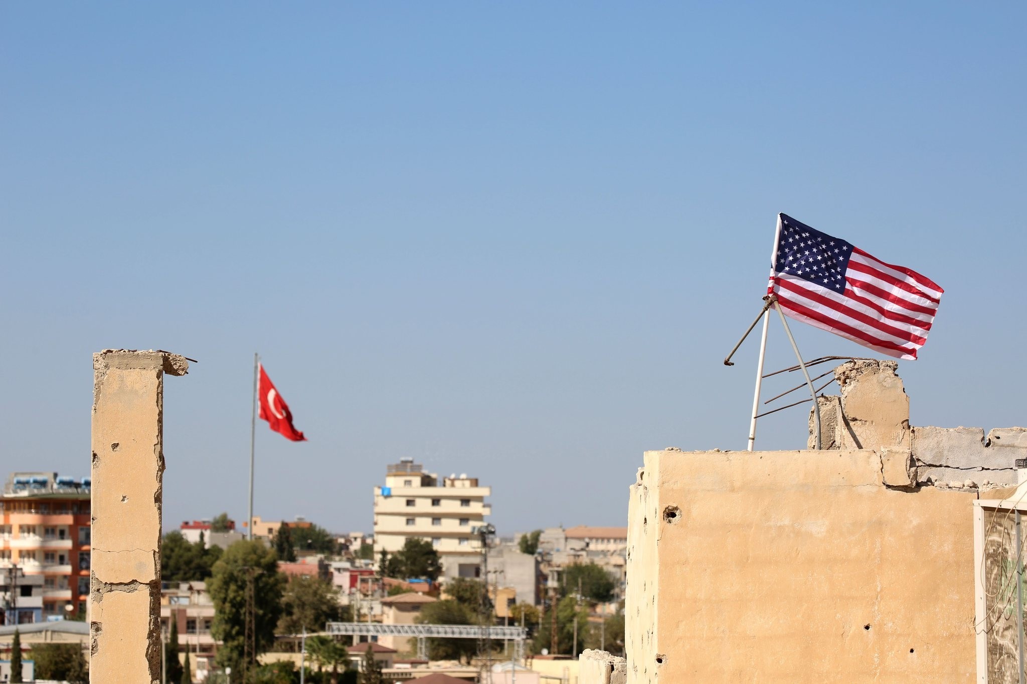 A U.S. flag fluttering above a building used by PYD forces in Tal Abyad, Syria on the border with Turkey, where a Turkish flag can be seen in the back, Sept. 17, 2016. 
