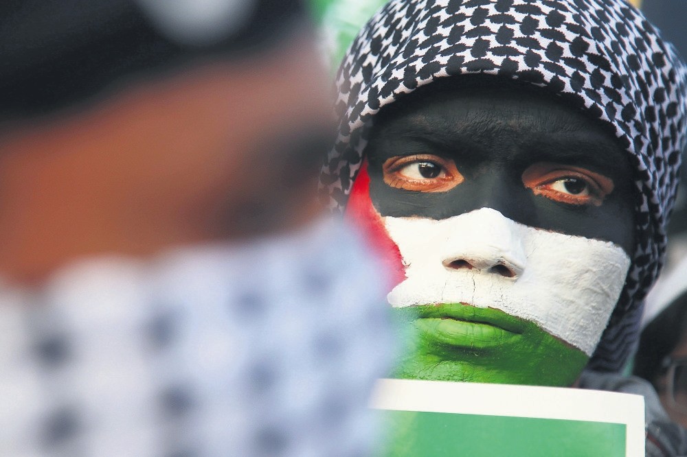 A protestor wears face print resembling the Palestinian flag during a rally against Trump's Jerusalem decision.