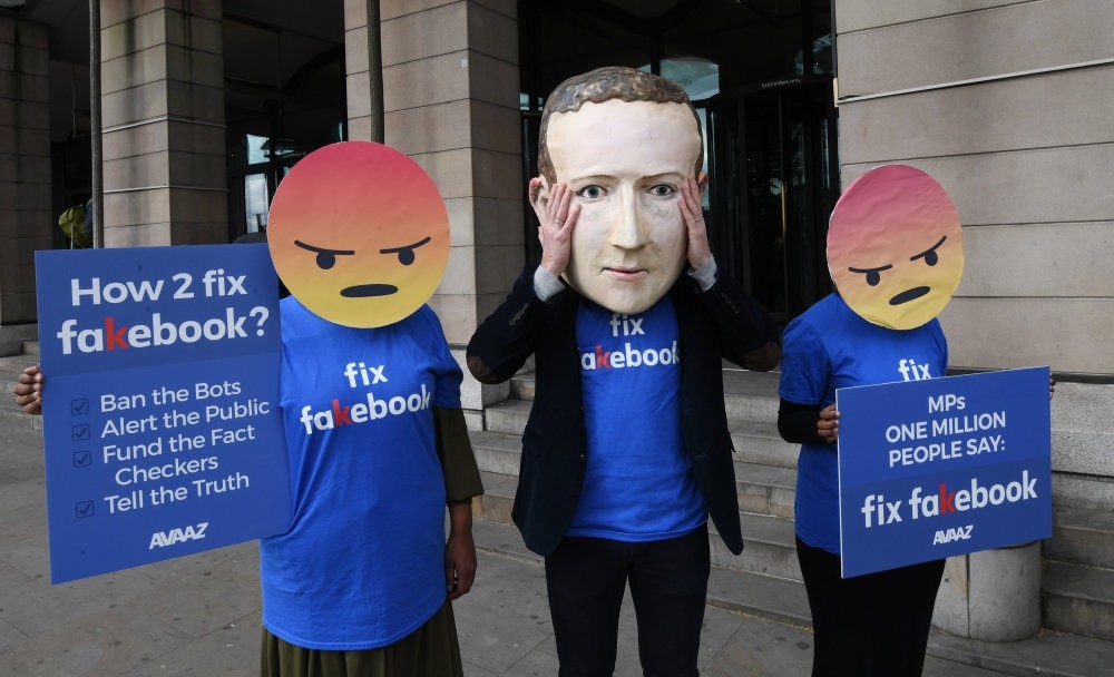 A protester wearing a mask depicting Facebook's CEO, Mark Zuckerberg, protests outside Portcullis House in central London, Apr. 26.