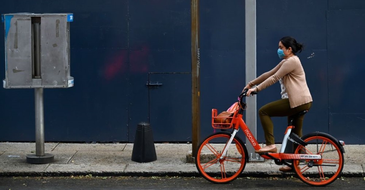 A woman rides a bike wearing a face mask in Mexico City, May 17, 2019.
