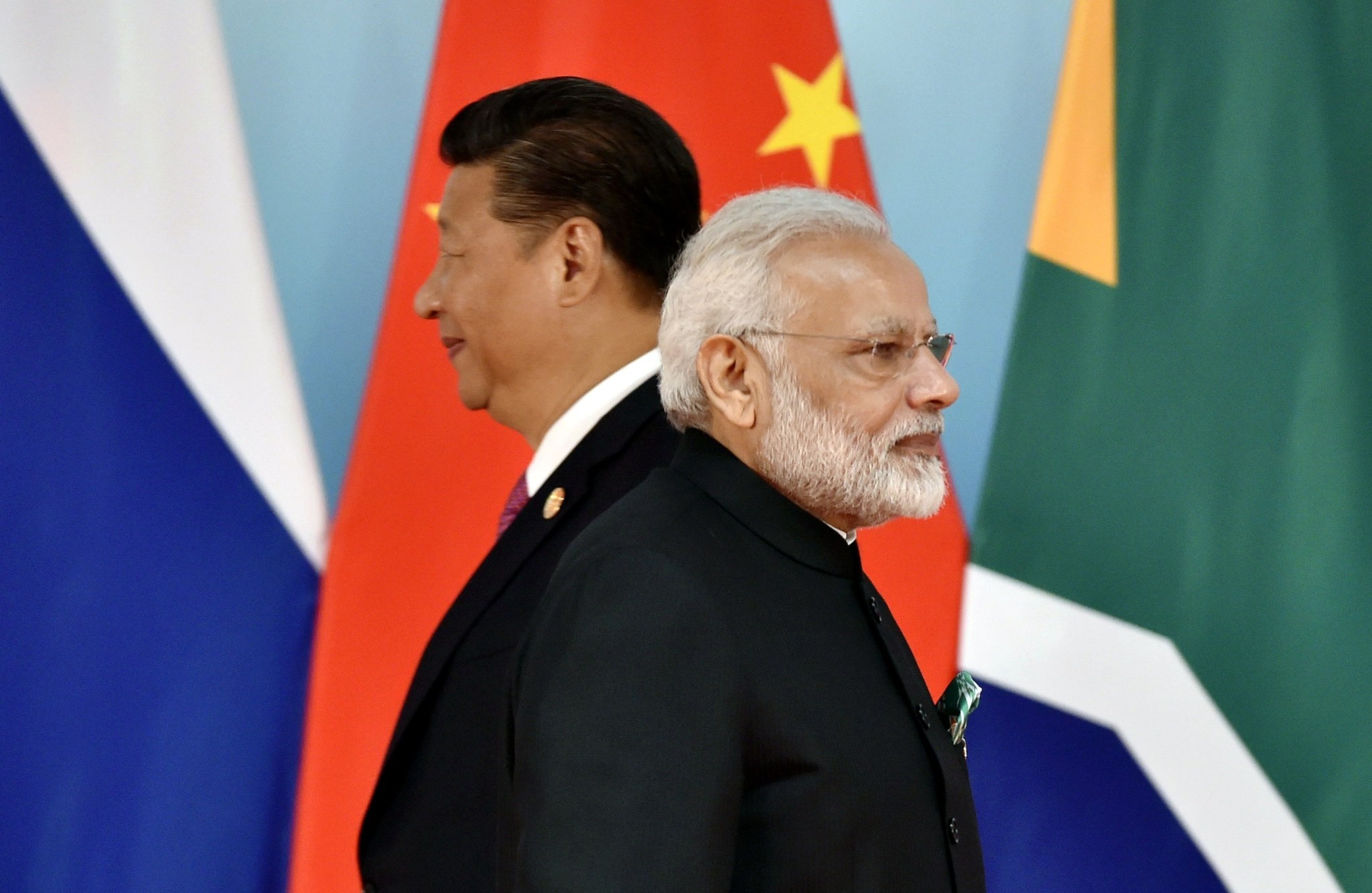 Chinese President Xi Jinping (L) and Indian Prime Minister Narendra Modi walk past each other as they attend a group photo session during the 2017 BRICS Summit in Xiamen, the Fujian province, China, Sept. 4.