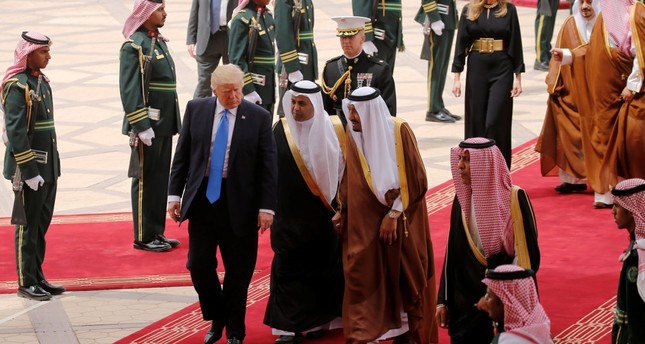 Saudi Arabia's King Salman (C, in brown and white) welcomes President Trump with a military honor cordon after they arrived the King Khalid International Airport in Riyadh, Saudi Arabia, May 20.
