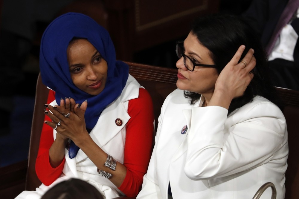 U.S. Rep. Ilhan Omar (L) and Rep. Rashida Tlaib listen as U.S. President Donald Trump delivers his State of the Union Address to a joint session of Congress on Capitol Hill, Washington, Feb. 5, 2019.