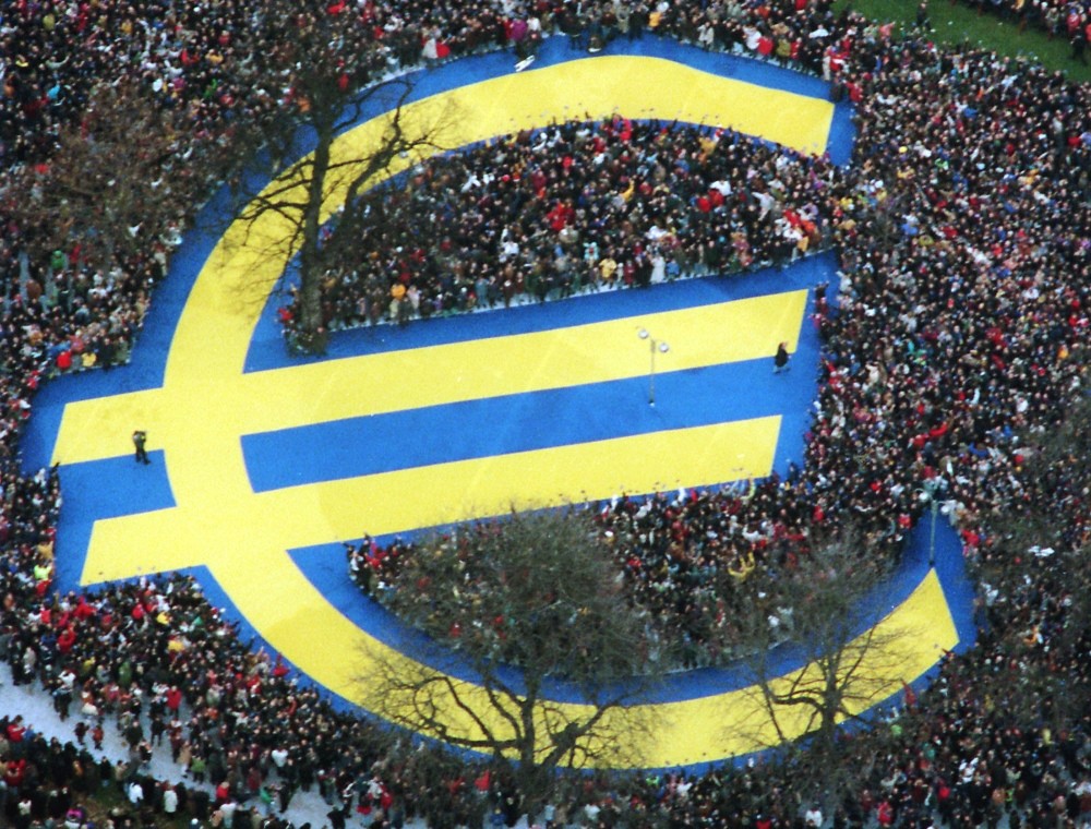 In this Friday, Jan. 1, 1999 photo, thousands of people stand around a huge euro symbol displayed in a park in Frankfurt's banking district on the day of the launch of the euro.