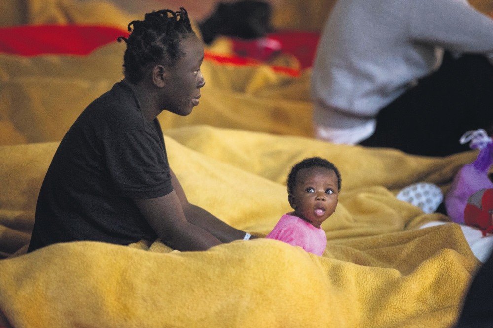 Migrants rest at a makeshift emergency center at Barbate's municipal sports center in the south of Spain, June 29.