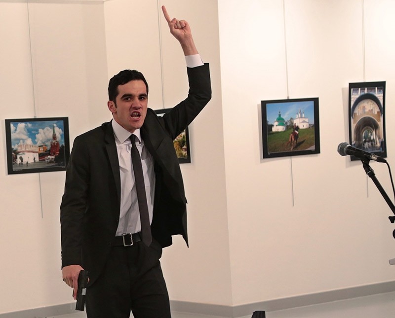 A man gestures after shooting Andrei Karlov, the Russian Ambassador to Turkey, on the floor, at a photo gallery in Ankara, Turkey, Monday, Dec. 19, 2016. (AP Photo)