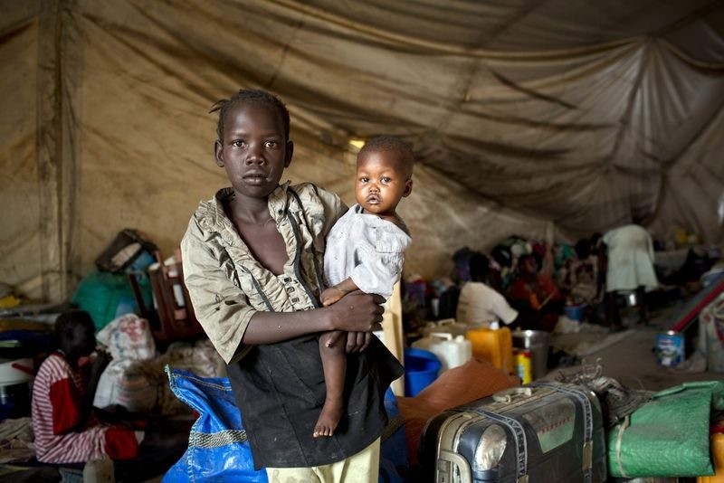 A young girl, displaced by recent fighting, holding her baby brother in a tent on the UN base in what is now home to 16,000 people in Malakal, South Sudan, 30 March 2014. (EPA Photo)