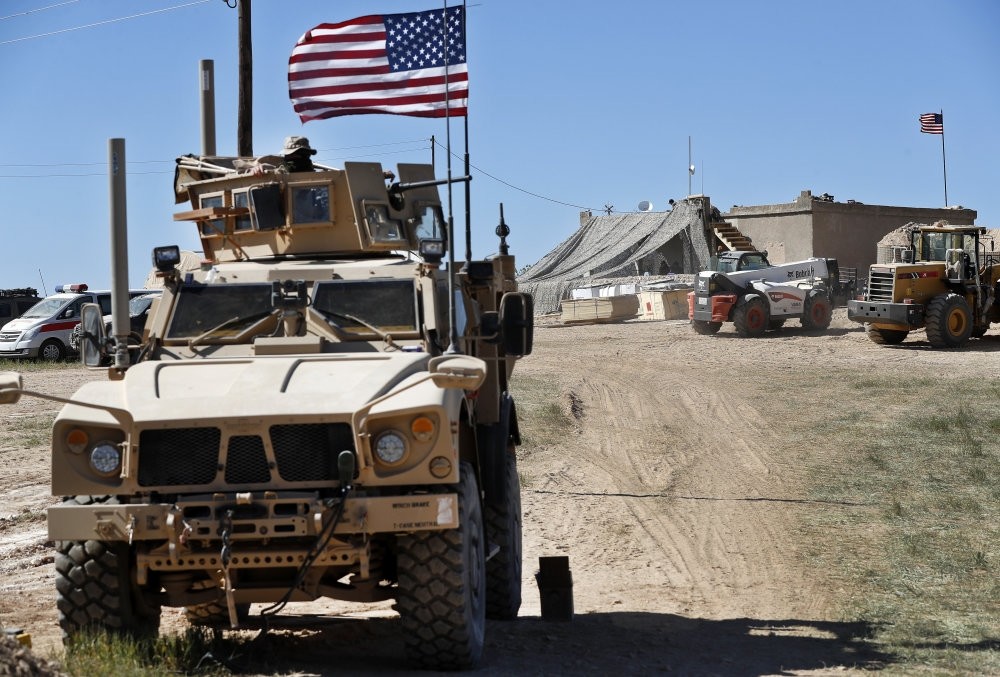 A U.S. soldier sits on an armored vehicle behind a sand barrier at a newly installed position in Manbij, April 4, 2018.