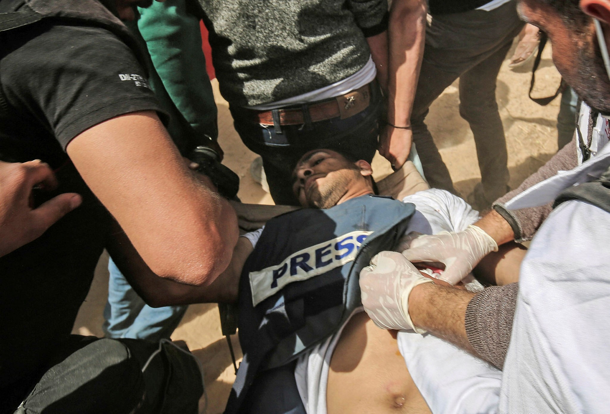 Demonstrators assist an injured Palestinian journalist Yasser Murtaja during clashes with Israeli security forces following a protest near the border with Israel, east of Khan Yunis, in the southern Gaza Strip, on April 6, 2018. (AFP Photo)