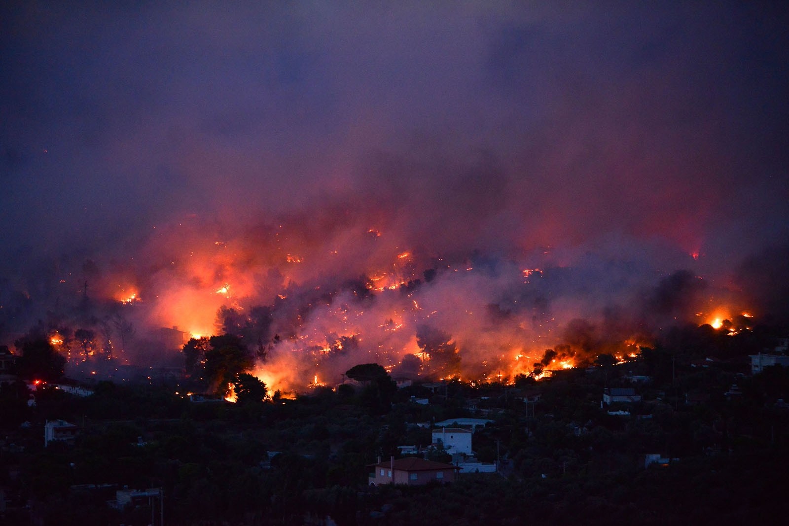 Flames rise as a wildfire burns in the town of Rafina, near Athens, July 23, 2018.