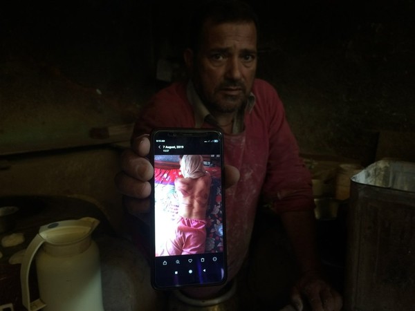 In this Monday, Aug. 26, 2019, photo, a Kashmiri baker Sonaullah Sofi displays a photograph of his son after he was allegedly tortured by Indian army soldiers at their bakery in the southern village of Parigam, Indian controlled Kashmir. (AP Photo)
