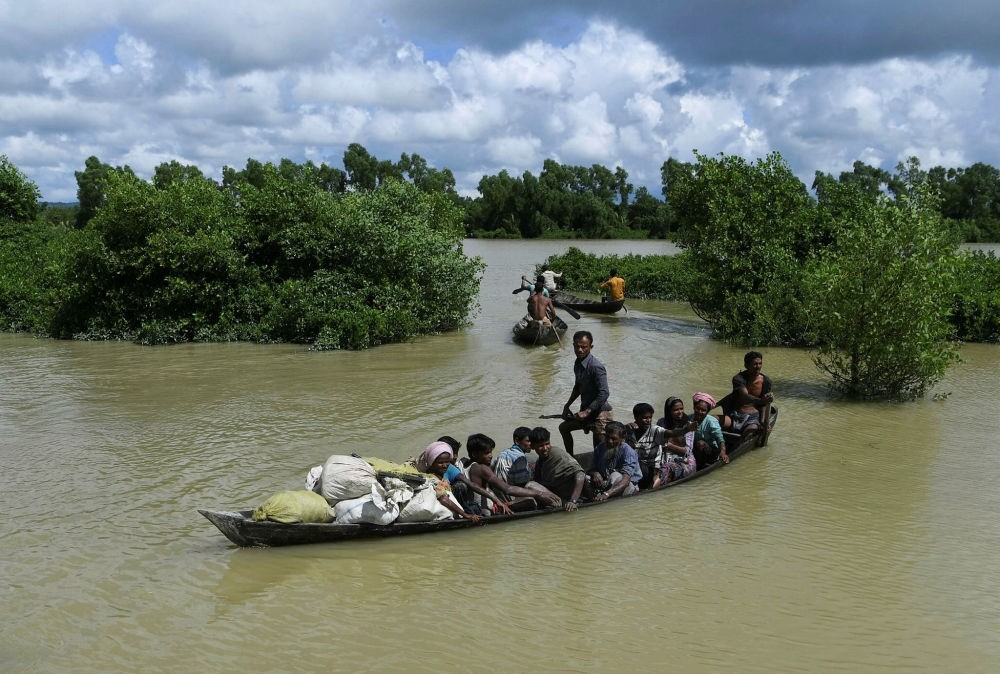 Rohingya refugees arrive on a boat after crossing the Naf river from Myanmar into Bangladesh in Whaikhyang, Oct. 9.